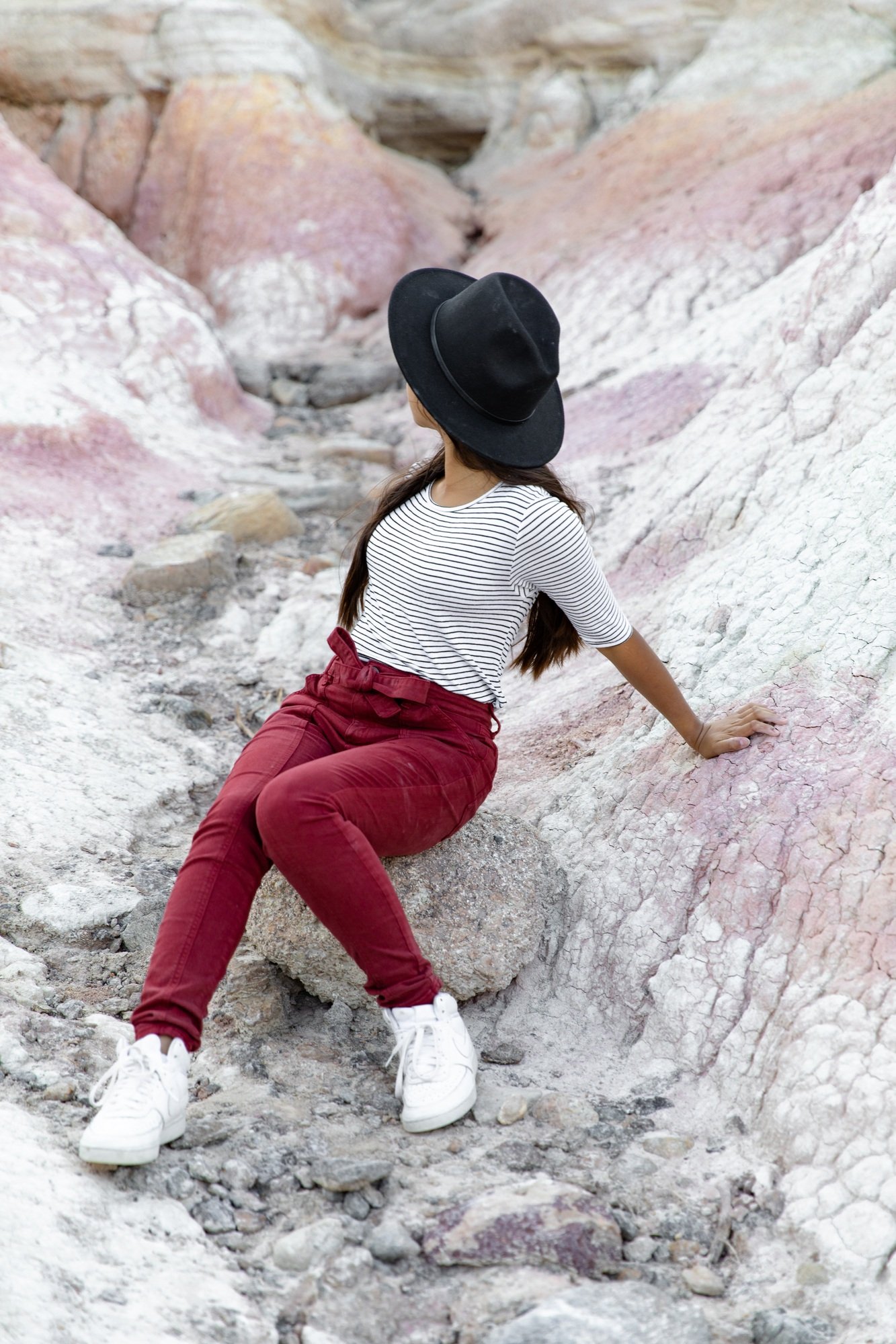 Girl sitting in rocks wearing fashions clothes
